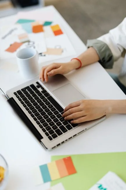A modern office setup featuring a laptop and a whiteboard schedule for social media platforms.