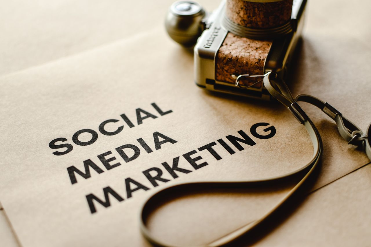 Close-up of a camera resting on brown paper with Social Media Marketing text, highlighting digital marketing themes.